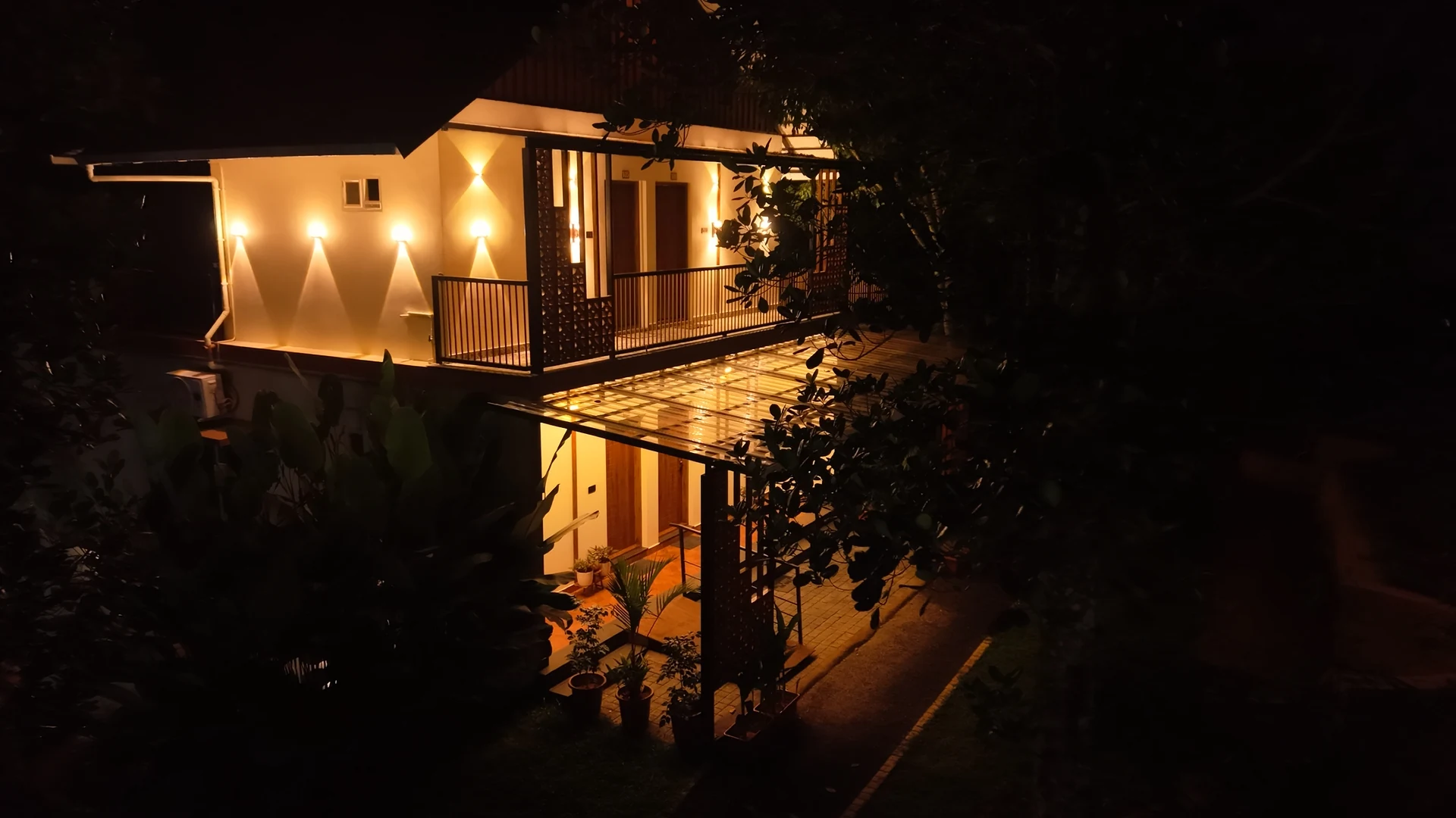 Warmly illuminated balcony rooms at East Village Resort after sunset